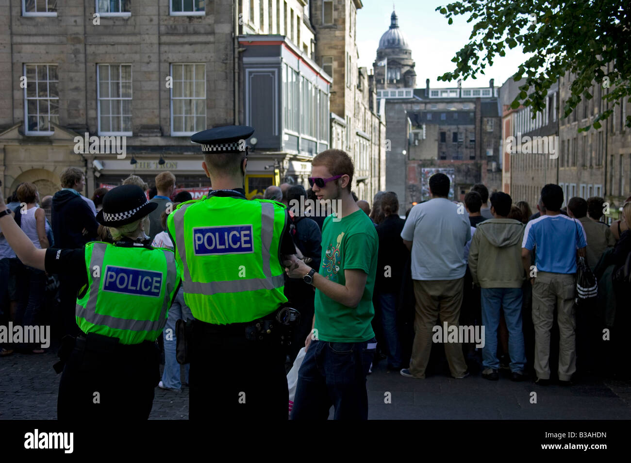 Junger Mann plaudert, zwei Polizisten, einem männlichen ein Weibchen, Hunter Square, Edinburgh, Schottland, UK, Europa Stockfoto