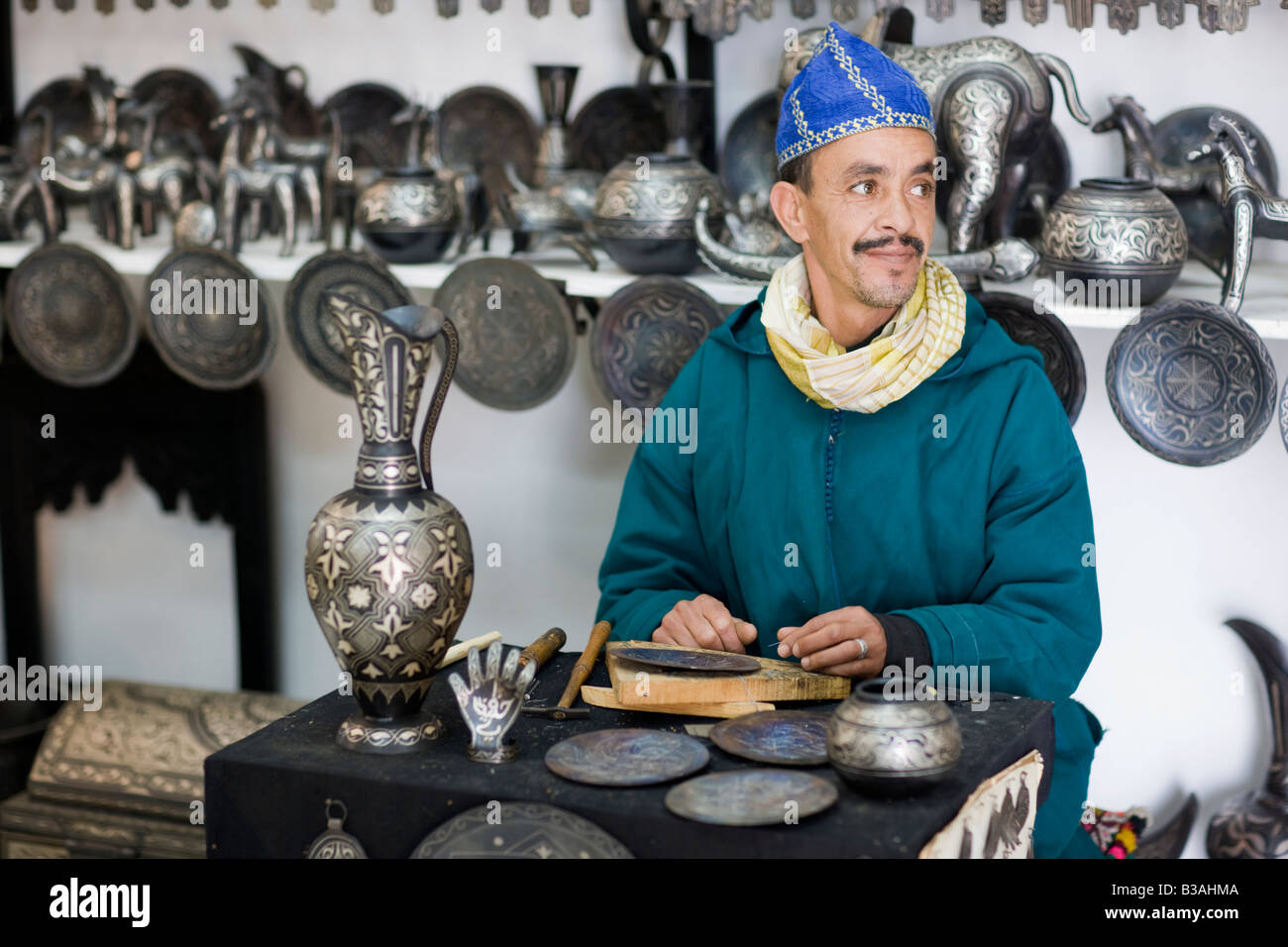 Afrika Marokko Marrakesch Medina Souks der Mann Hämmern dekoratives Muster in Messingtabletts Stockfoto