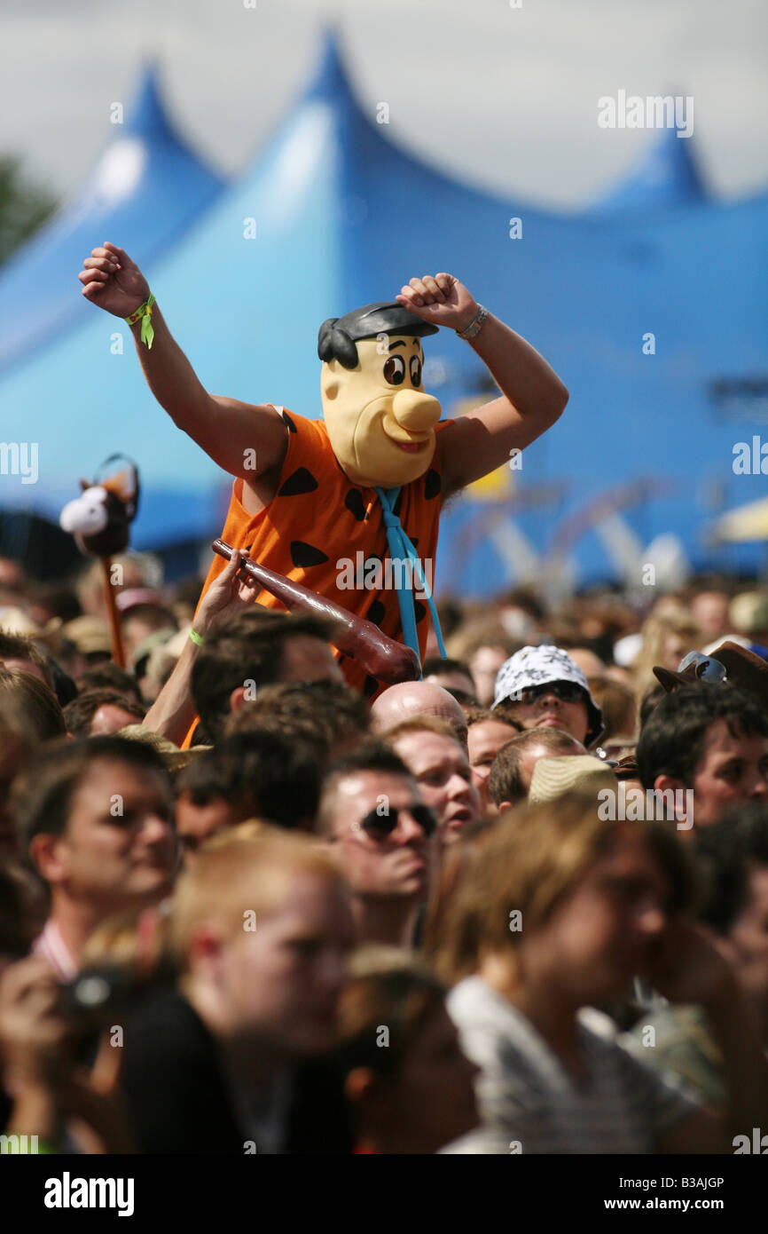 Jemand in der Menge verkleidete sich als Fred Flintstone genießen Sie die Musik auf dem V Festival im Hylands Park Chelmsford Essex Stockfoto