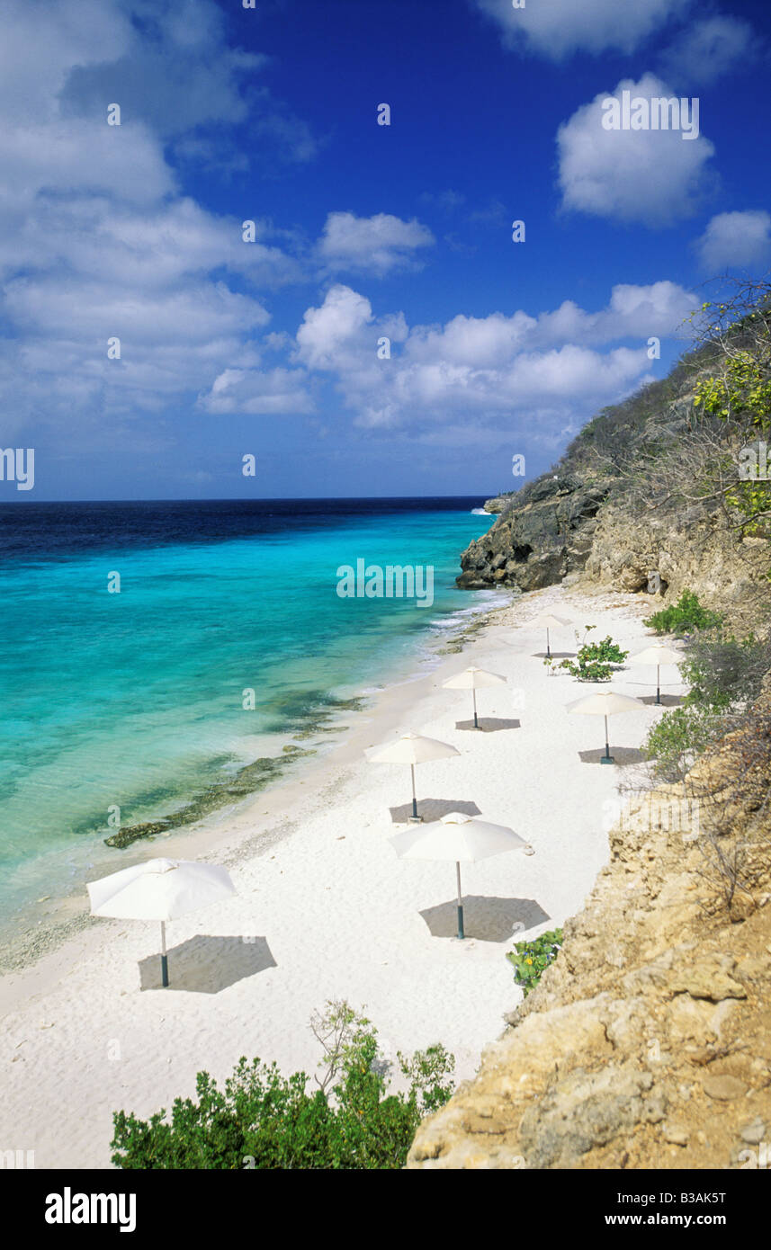 Karibik, Curacao, Niederländische Antillen, Playa Porto Marie Beach, sandigen Strand Sonnenschirme, Azure blauen Wasser. Stockfoto
