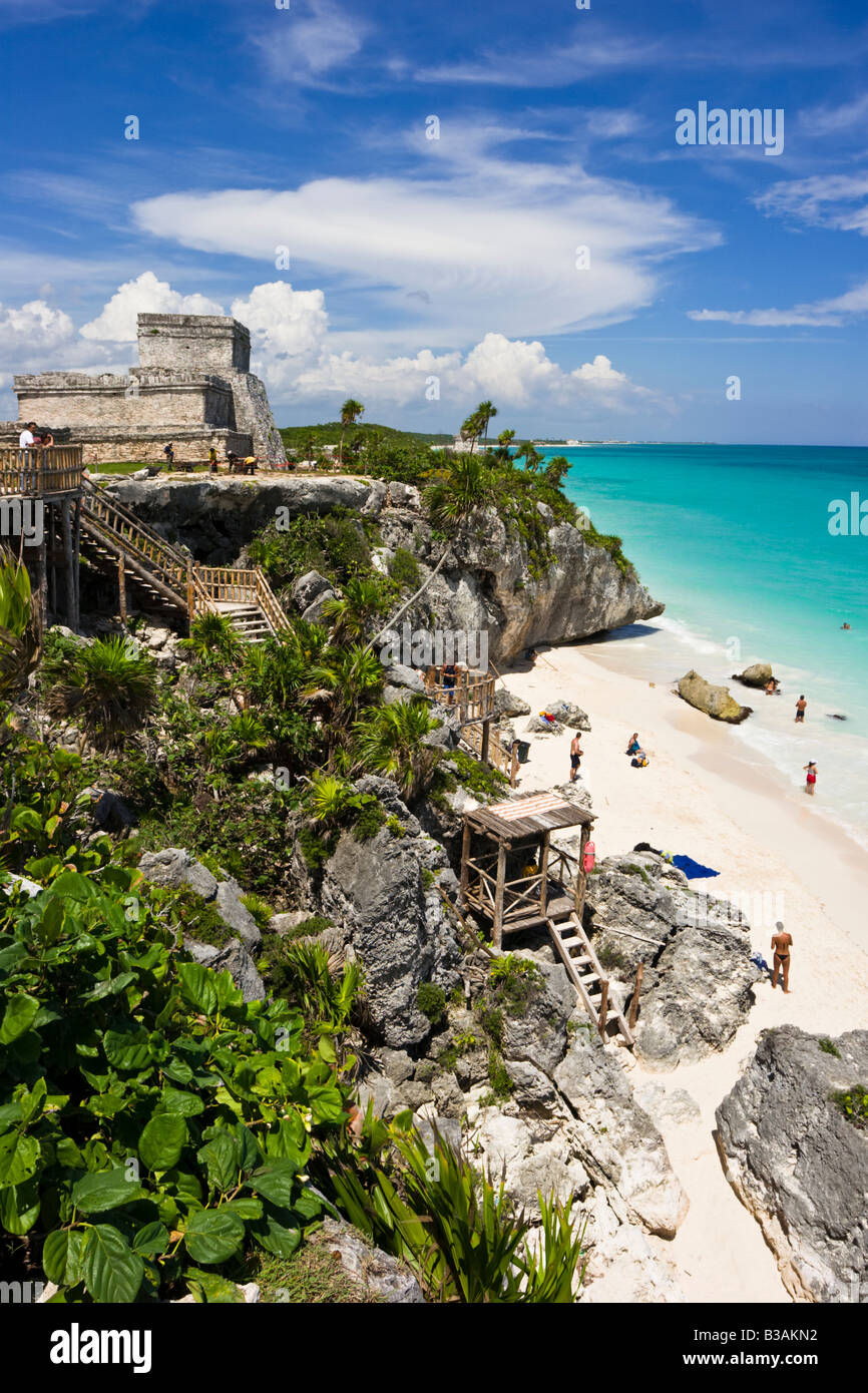 El Castillo (das Schloss) und felsiger Strand mit Sonnenanbeter auf den Maya-Ruinen von Tulum in Quintana Roo, Mexiko. Stockfoto