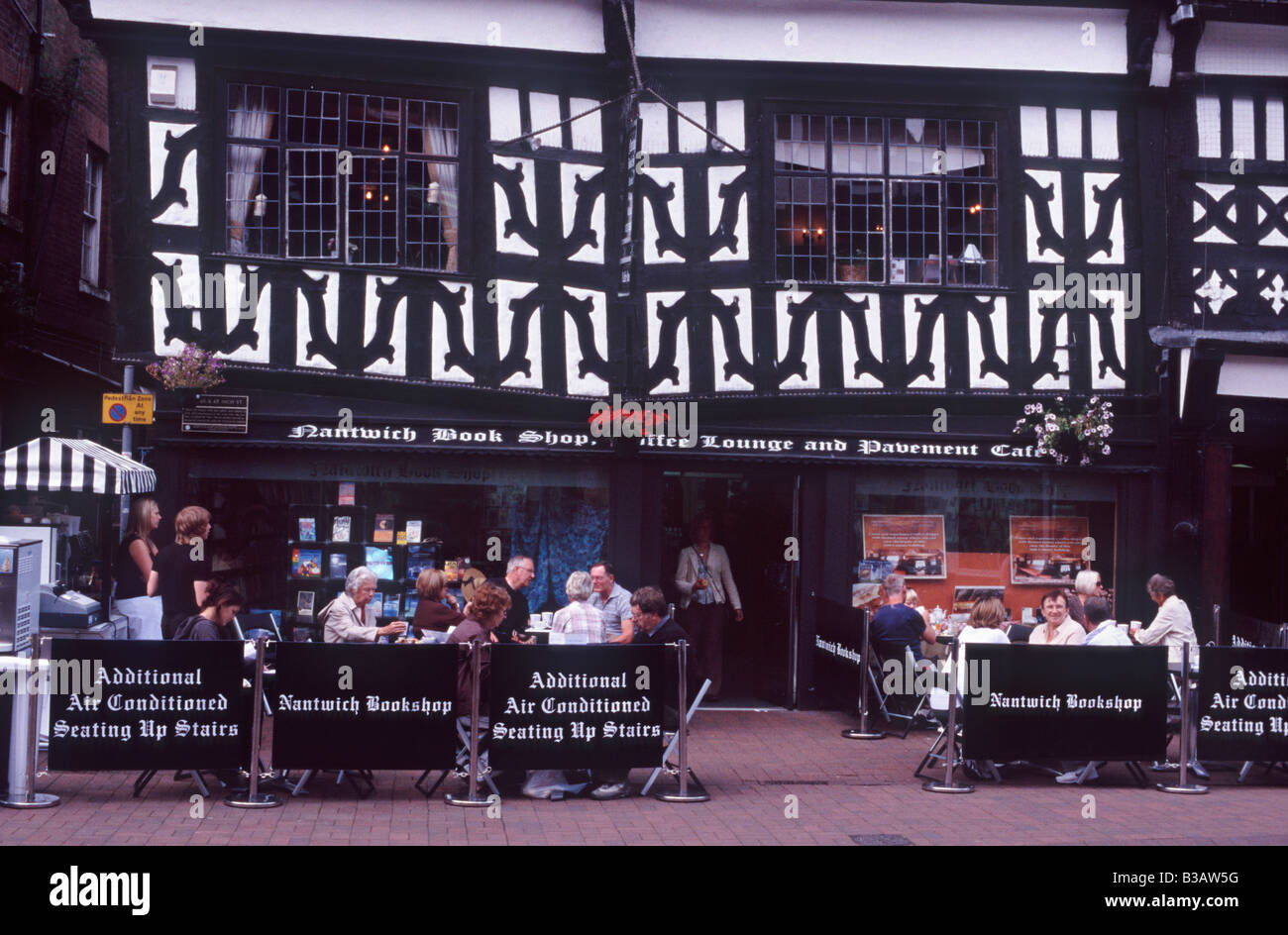 Menschen trinken Kaffee außerhalb der 16c schwarz und weiße Nantwich Buchhandlung Coffee Lounge und Pavement Cafe, Nantwich, Cheshire Stockfoto