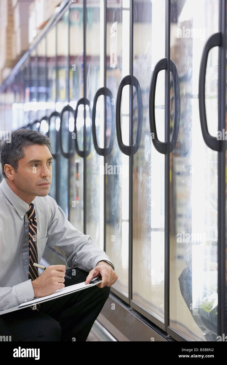 Hispanische Grocery Storemanager schreiben in Zwischenablage Stockfoto