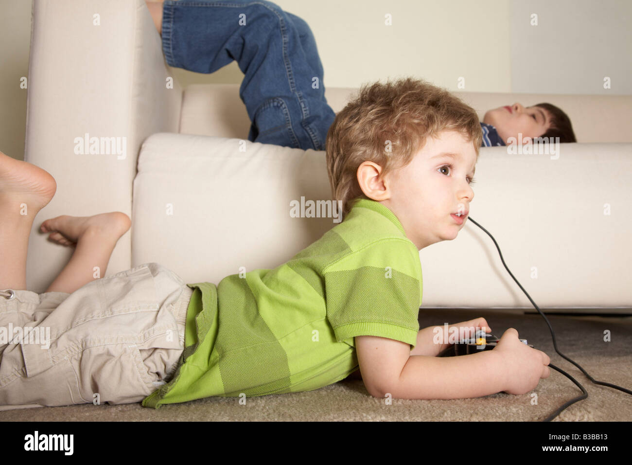 Jungen spielen von Videospielen, Bruder auf Sofa Stockfoto