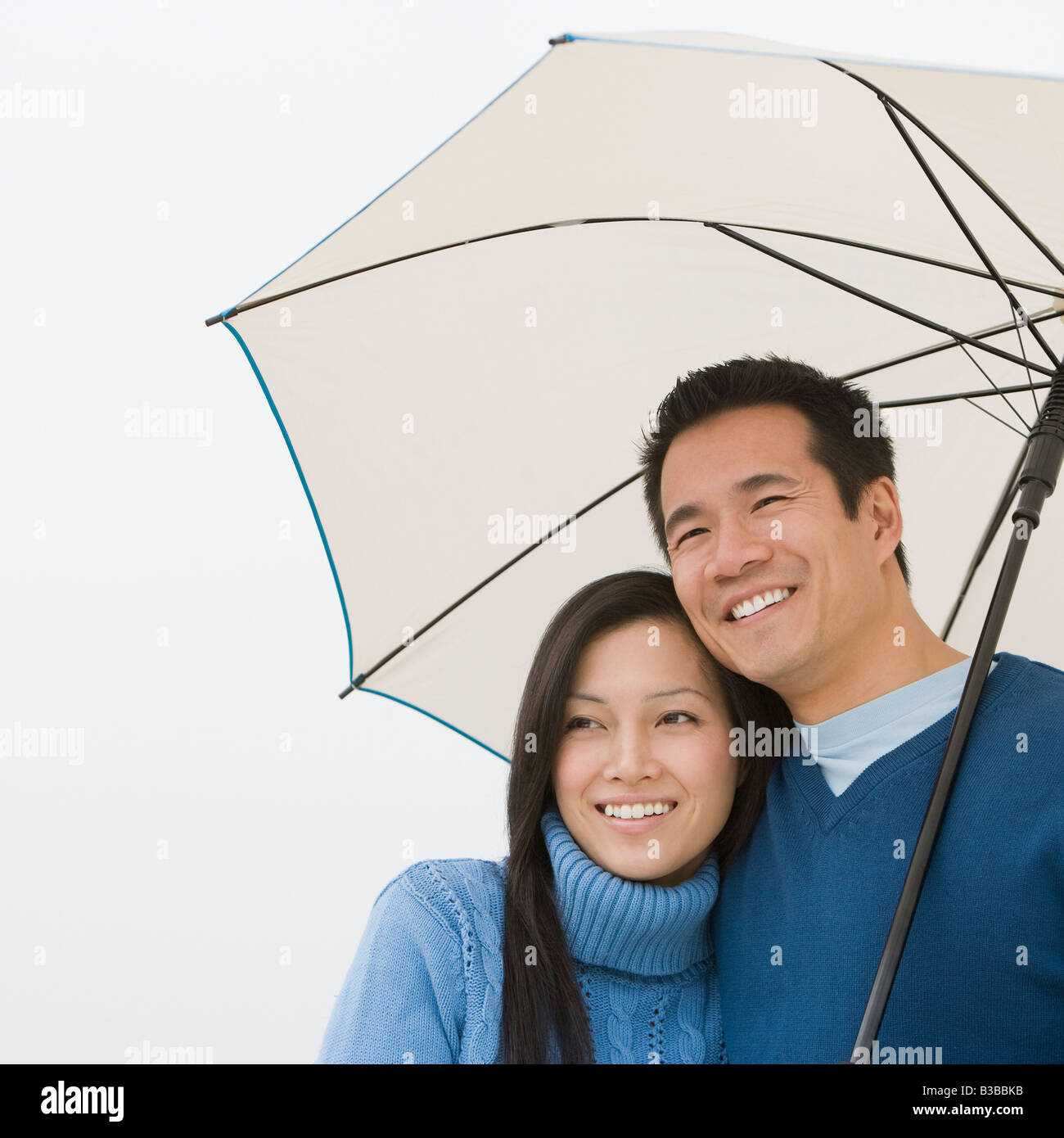 Asian paar umarmt unter Dach Stockfoto