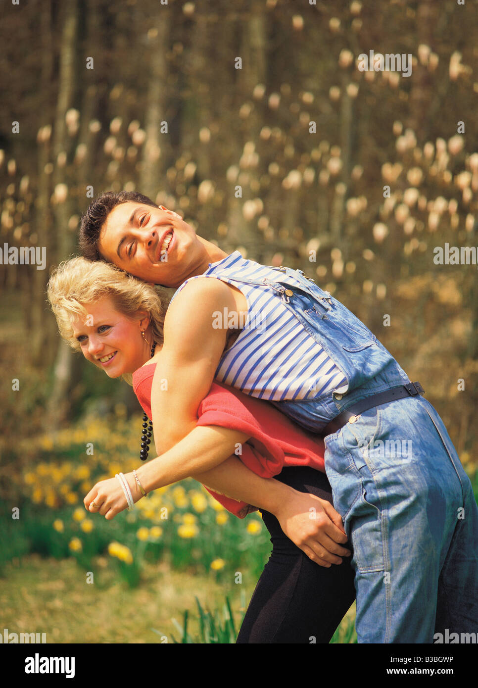 Paar mit Arme verbunden und Frau Mann auf den Rücken heben Stockfoto