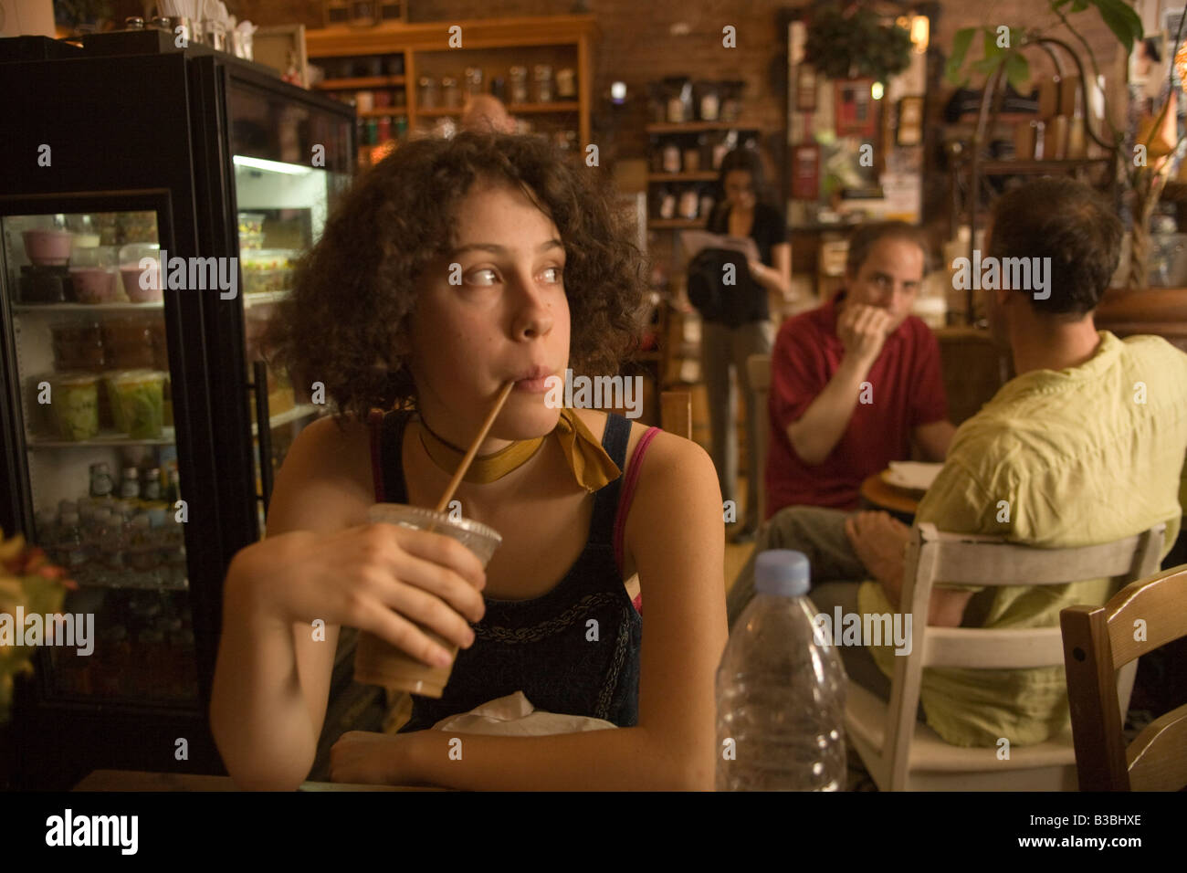 Junge Frau hat einen Eiskaffee an einem heißen Sommertag in einem Café auf der oberen Ostseite von Manhattan Stockfoto