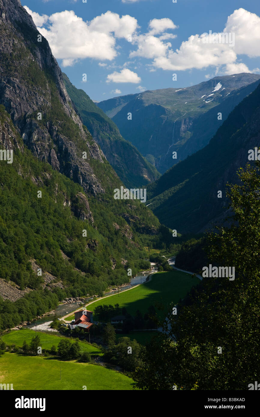 Vertikale bunte landschaftlich schönen grünen Tal in norwegischen Sogndal in der Nähe von gudvangen Norwegen mit Bergbach und entfernten Wasserfall, blauer Himmel Stockfoto
