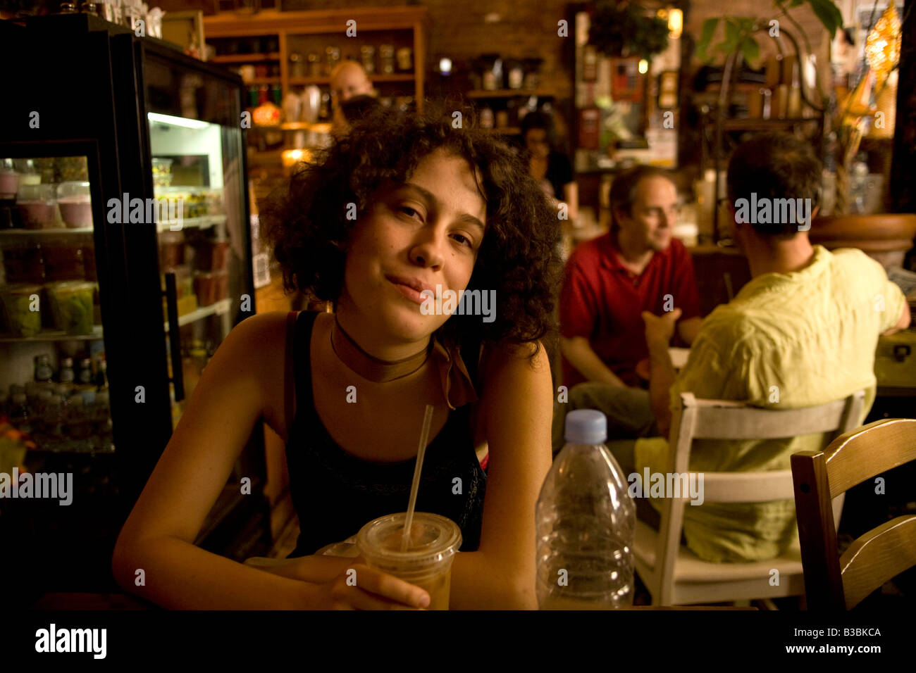 Junge Frau hat einen Eiskaffee an einem heißen Sommertag in einem Café auf der oberen Ostseite von Manhattan Stockfoto