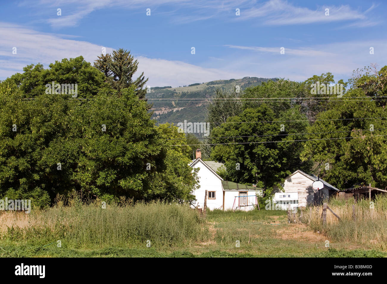 Kleine Pioniere Bauernhaus in zentrale Utah. Wasatch Mountains im Hintergrund. Alte Bäume und Garten. Stockfoto
