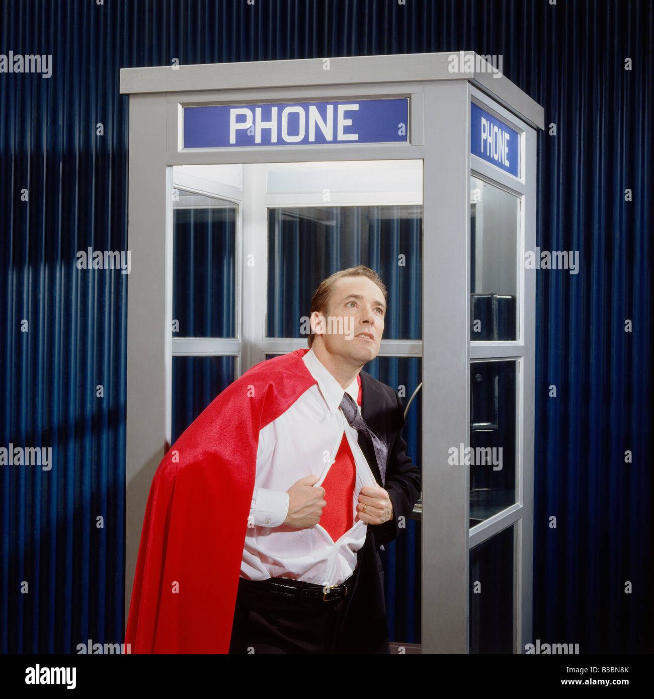 Mann Eröffnung Shirt Reveal Superhelden Kostüm in Telefonzelle Stockfoto