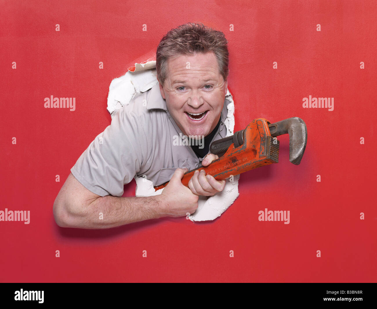 Klempner platzen durch Wand Stockfoto