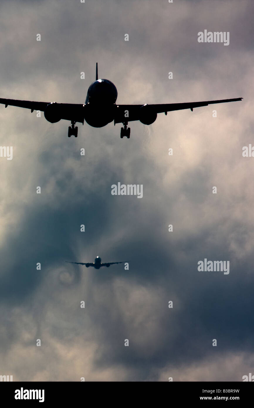 Wecken Sie Turbulenz Formen hinter Flugzeugen als sie Pässe durch die Wolken beim Abstieg zur Landung. Flughafen London Heathrow UK Stockfoto