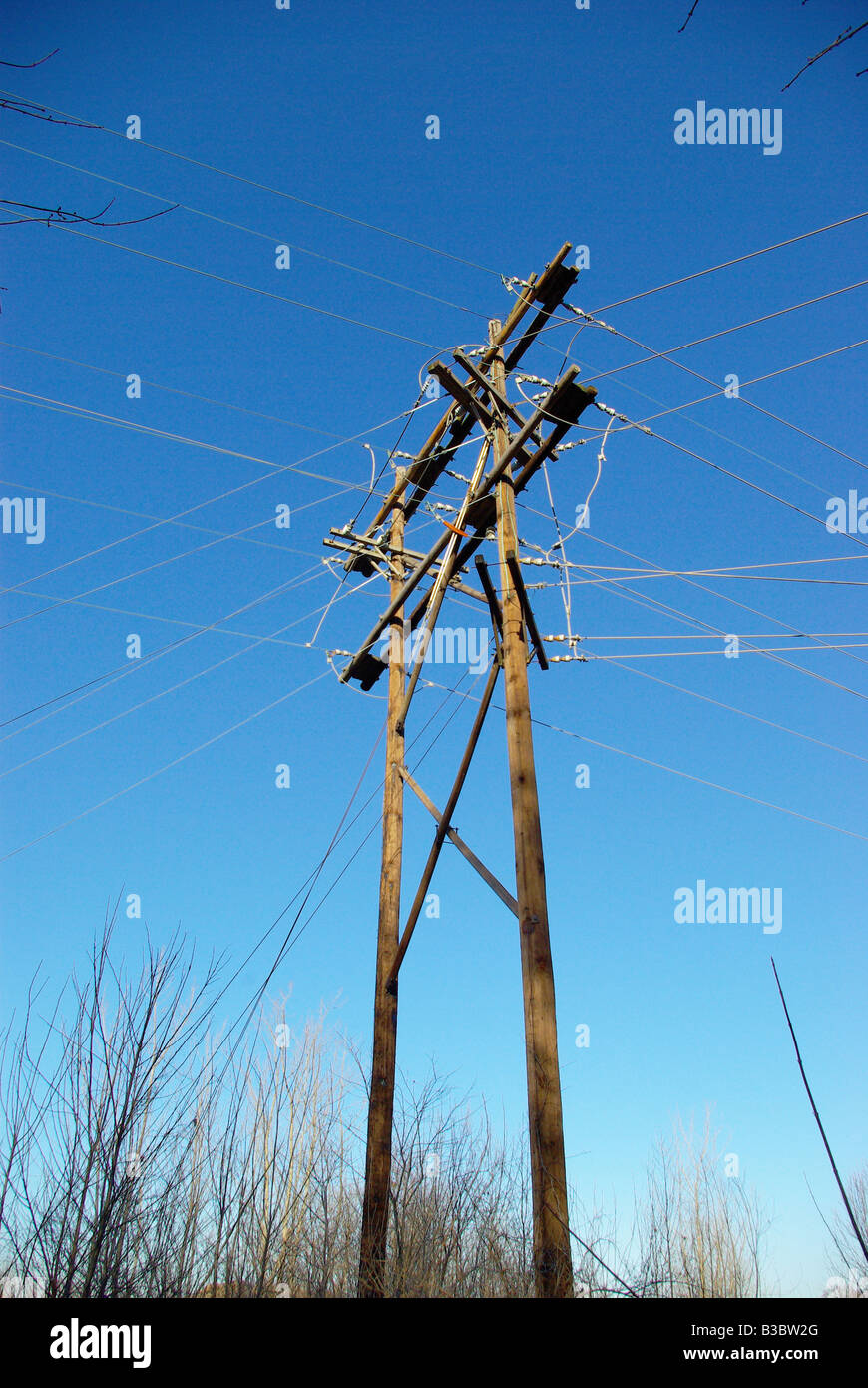 Hölzerne Strommast mit crossing Drähte gegen einen blauen Himmel in der Nähe von Lafayette IN Stockfoto