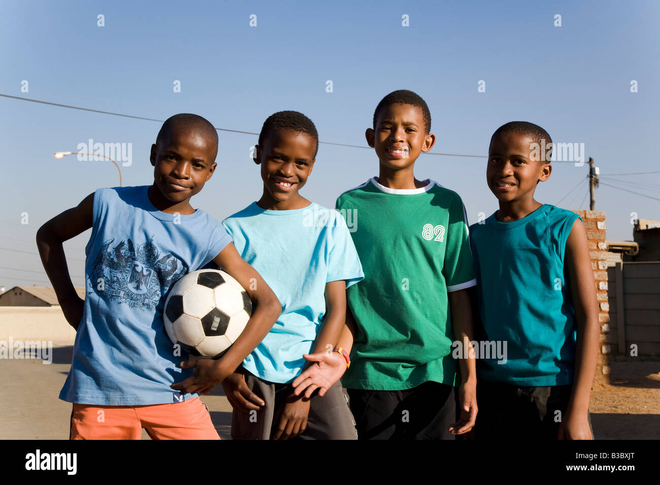 afrikanischen jungen spielen Fußball auf der Straße Stockfoto