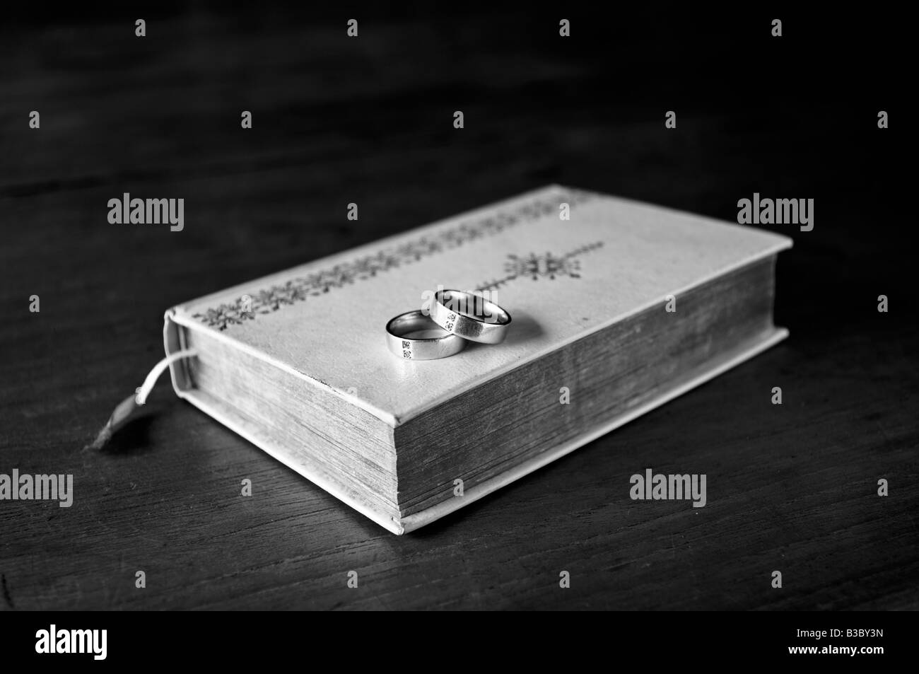 Bibel mit Ringen auf einem Tisch Stockfoto