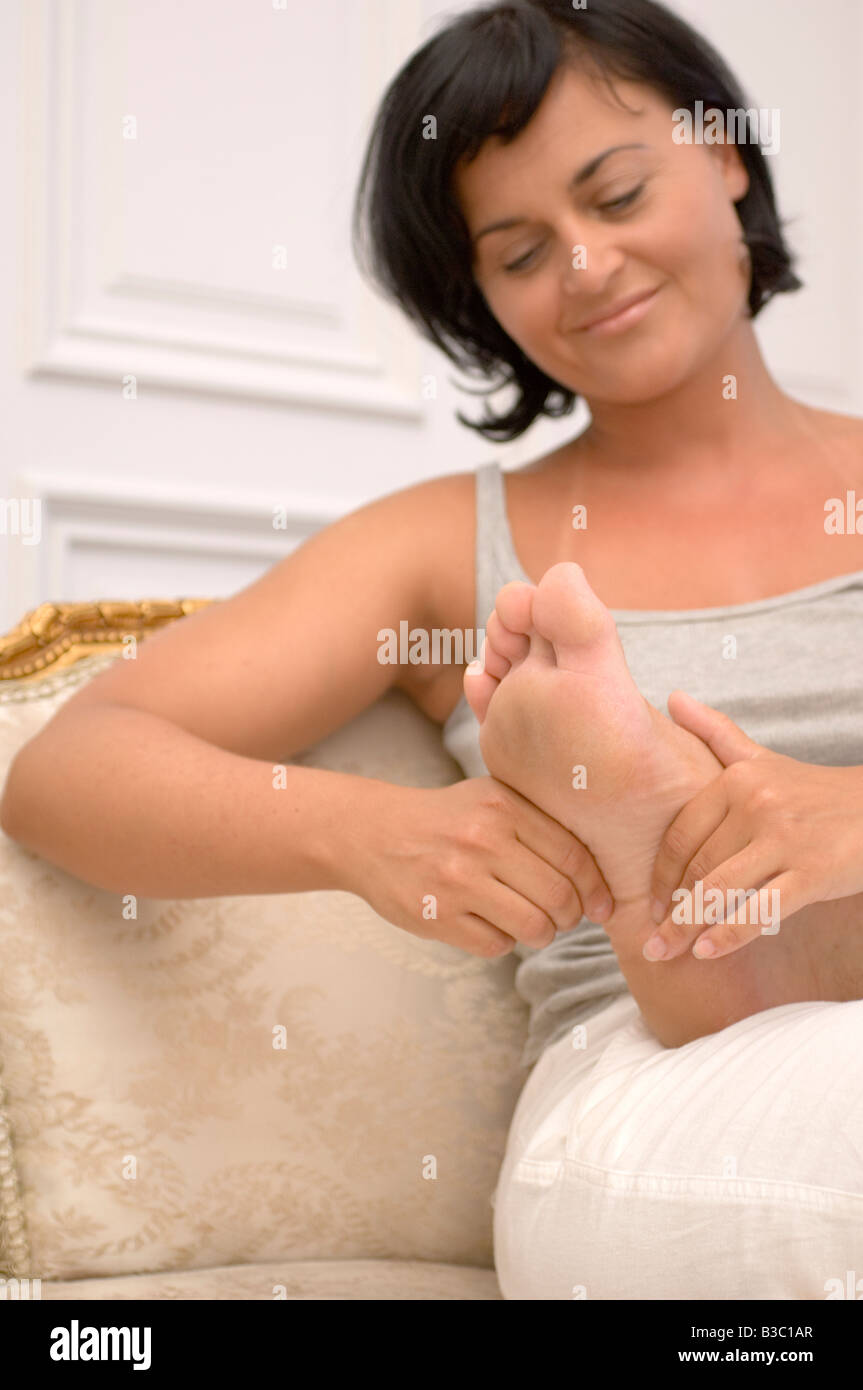 Eine Frau, die ihrem Partner eine Fußmassage geben Stockfoto