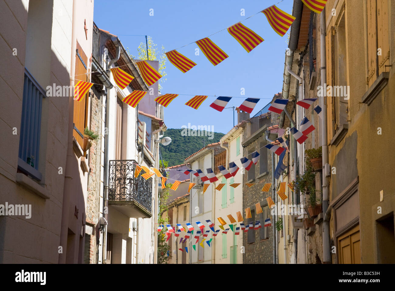 Eine Straße ist für den französischen Nationalfeiertag mit Fahnen und Luftschlangen in Katalanisch und Französisch Farben geschmückt. Stockfoto
