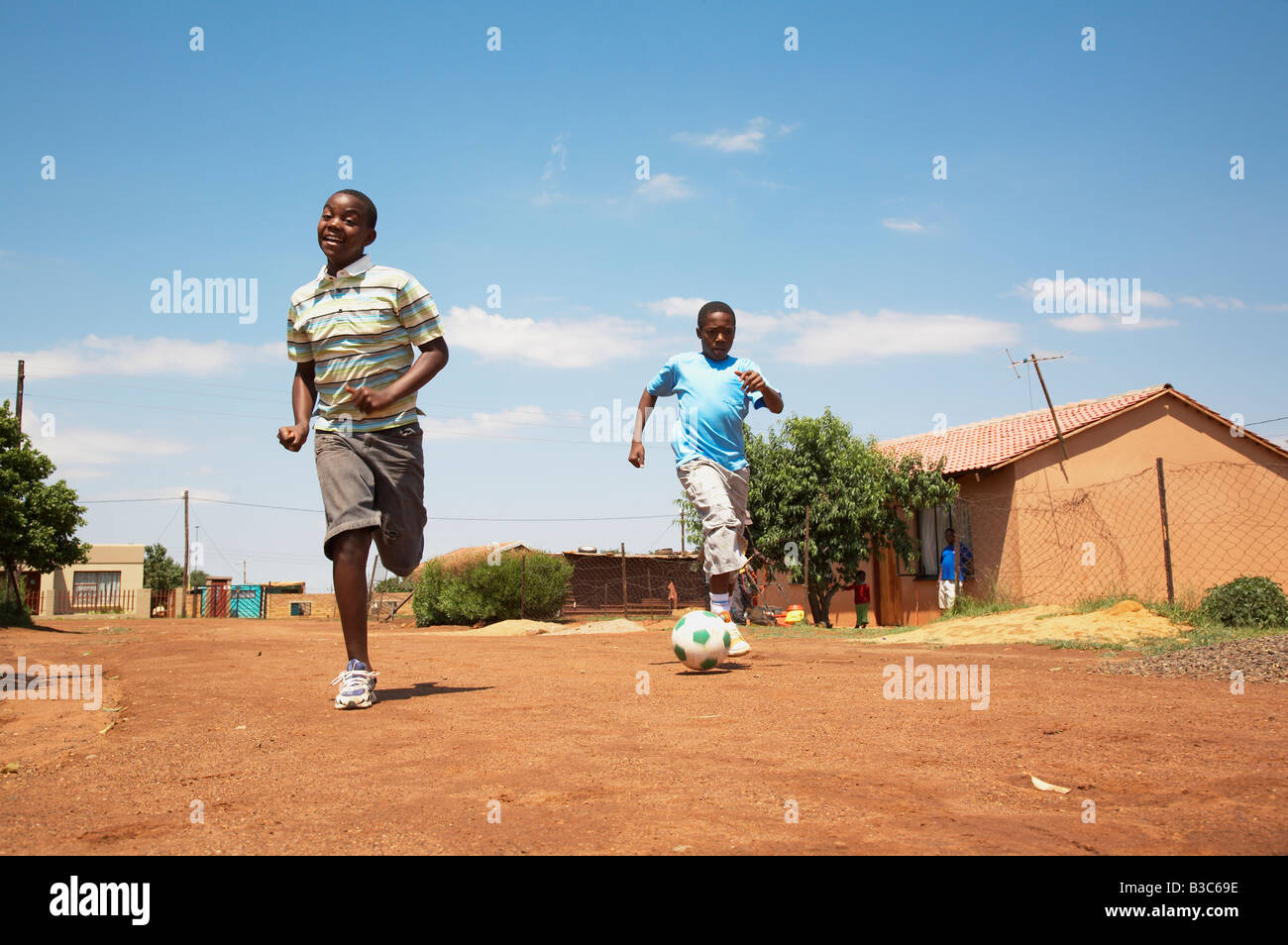 Township-Kinder spielen Fußball auf der Straße. Orangenfarm Gauteng MonkeyApple Stock Fotografie cc 2007 veröffentlicht Stockfoto