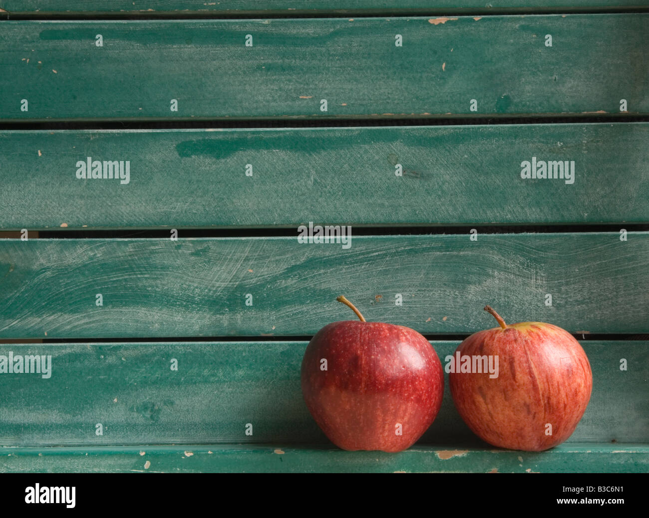 Zwei rote Äpfel im Hintergrund grün Lattenrost aus Holz (Querformat) Stockfoto