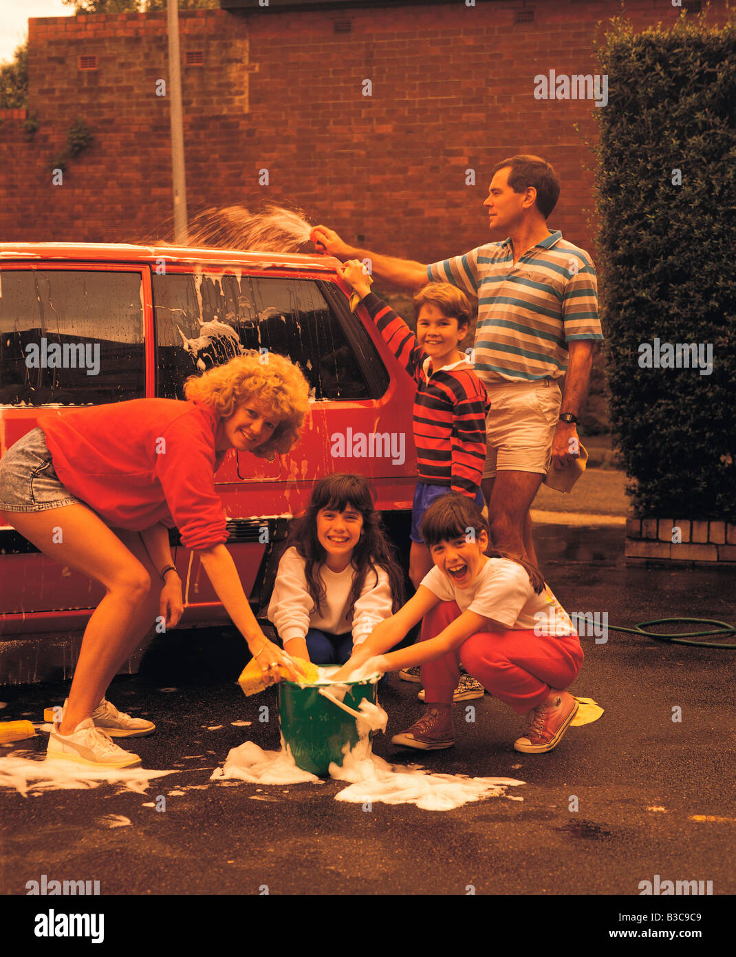 Familie Spaß beim Waschen ihr Autos Stockfoto