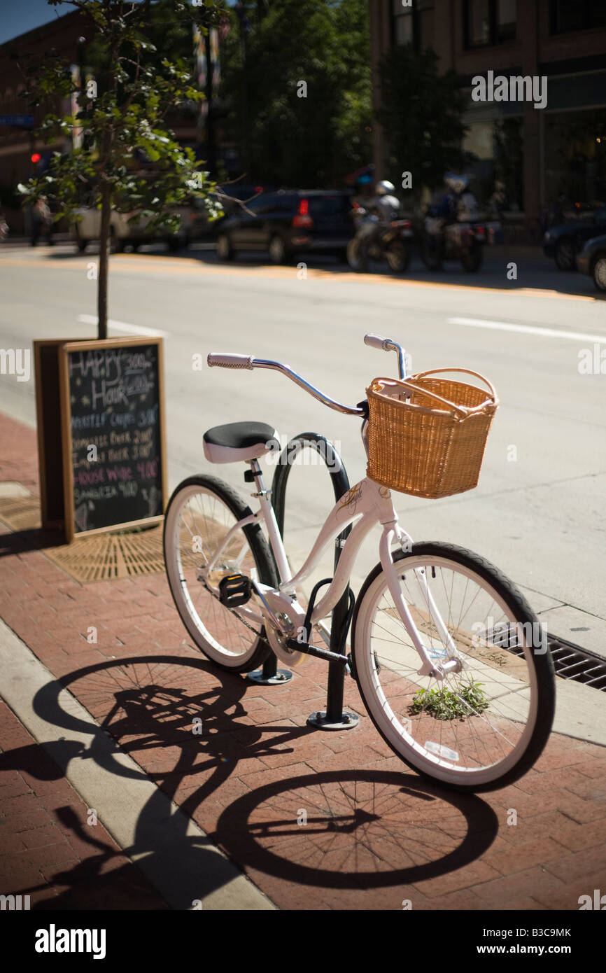 Weißen Fahrrad mit Weidenkorb parkten außerhalb ein Café auf einem Bürgersteig in der Innenstadt von Boulder, Colorado. Stockfoto Weißen Fahrrad mit Weidenkorb parkten außerhalb ein Café auf einem Bürgersteig in der Innenstadt von Boulder, Colorado. Stockfoto