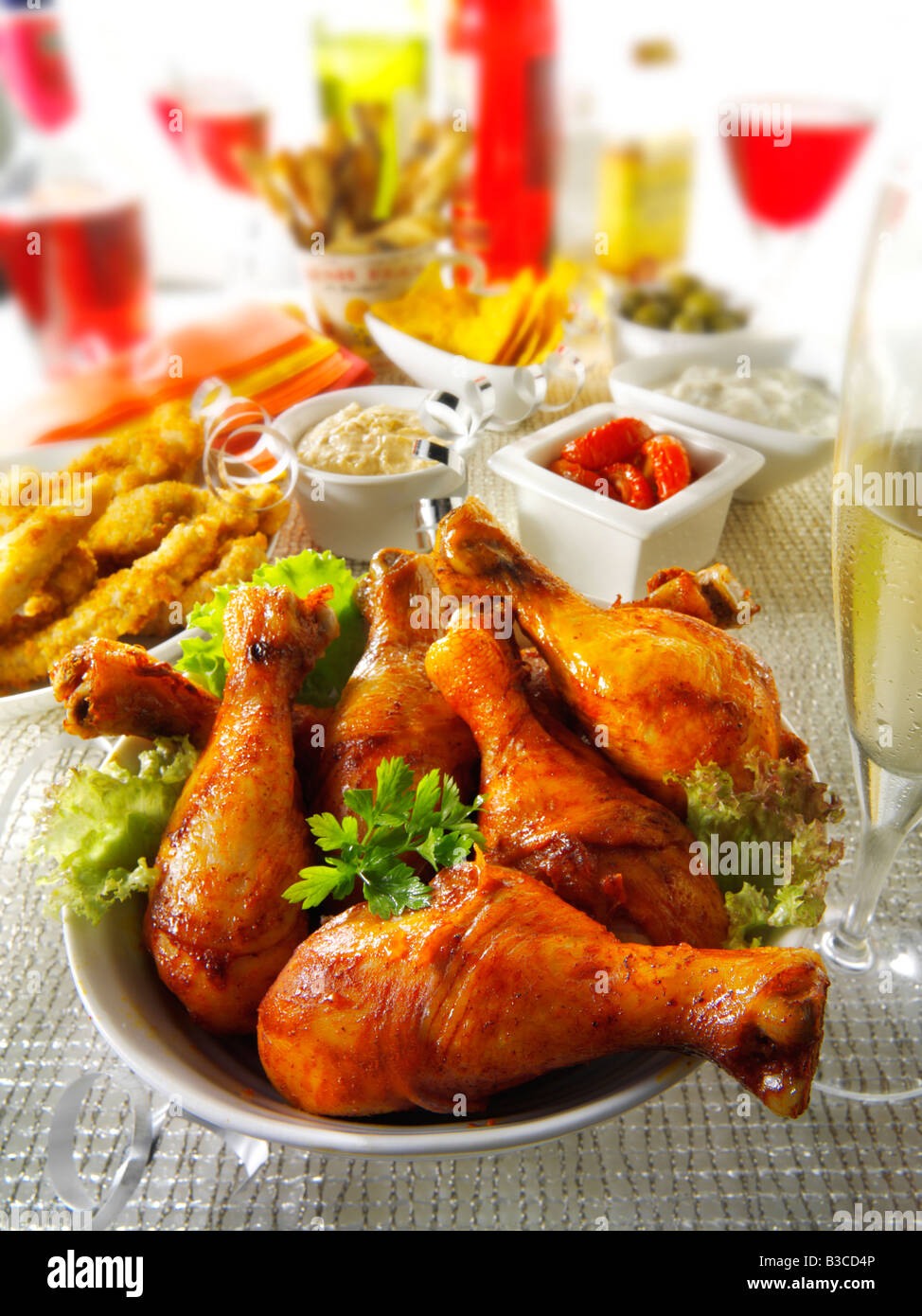 Party Essen Einstellung mit Chicken Drumsticks, Goujons und Sonne getrockneten Tomaten-dip Stockfoto
