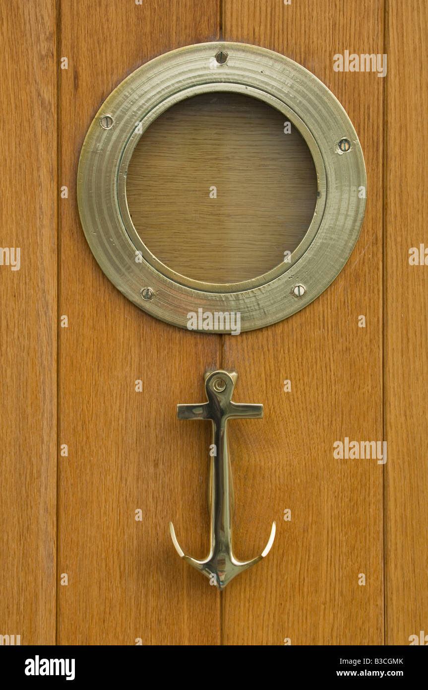 Eine nautische Thema Haustür mit Bullauge und Anker Klopfer auf einer Hütte am Kai im Hafen von Weymouth in Dorset Stockfoto