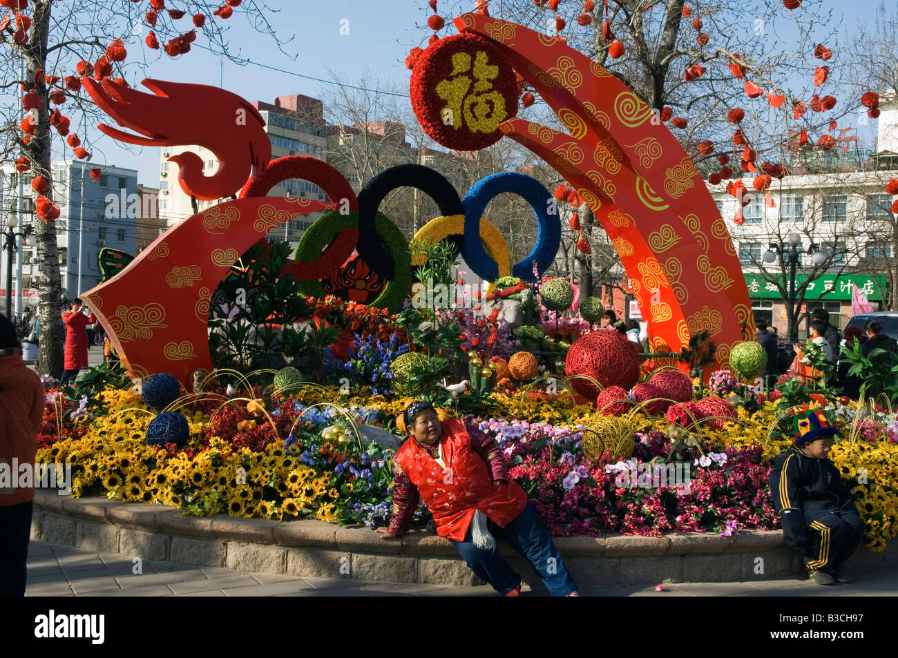 China, Peking. Chinese New Jahr Frühlingsfest - Blumenschmuck und eine Dame entspannend. Stockfoto