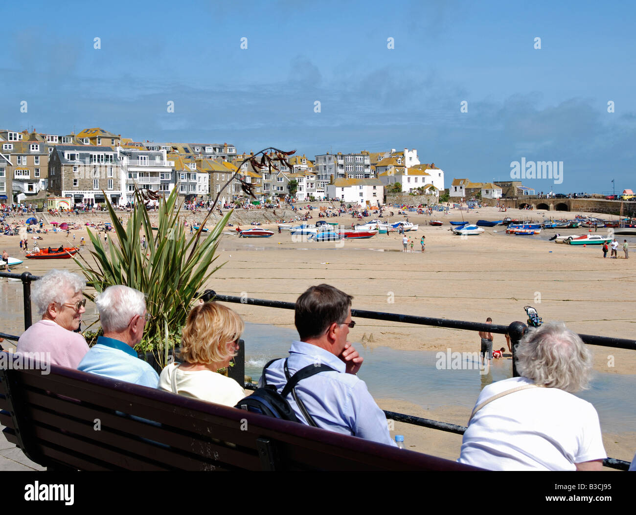 Seniorinnen und Senioren sitzen durch den Hafen von st.ives in Cornwall, Großbritannien Stockfoto