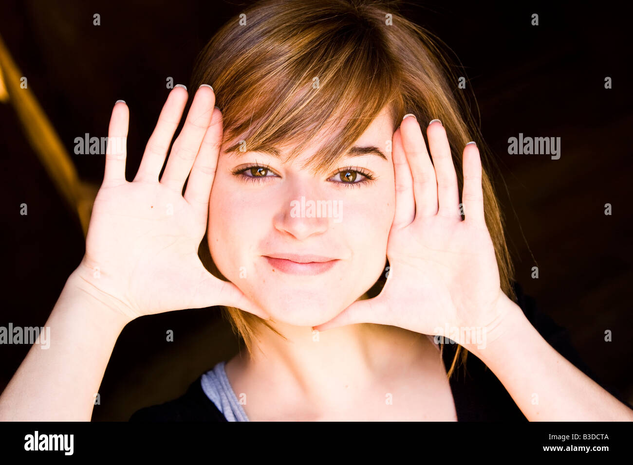 Schöne blonde Frau, die selbst mit ihren Händen einrahmen Stockfoto