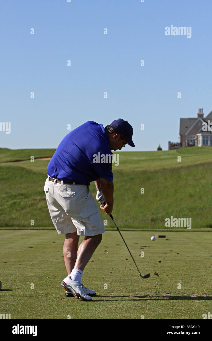 Golfer mit einer großen Golfschwung trifft seinen Abschlag erschossen auf einem Par 3 bergauf. Stockfoto