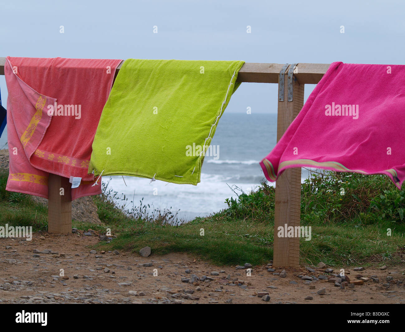 Farbenfrohe Strandtücher hängen über einen Zaun Widemouth Bay Beach. Stockfoto