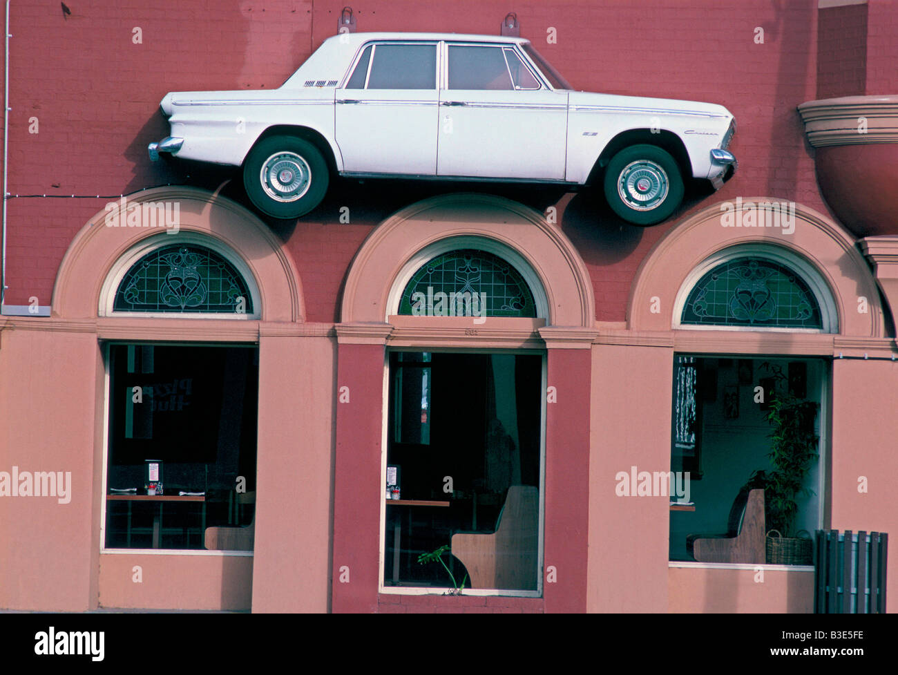 HALBEN KÖRPER WEIß AUTO ALS KUNSTWERK HING AN AUßENWAND RESTAURANT PERTH WESTERN AUSTRALIA Stockfoto