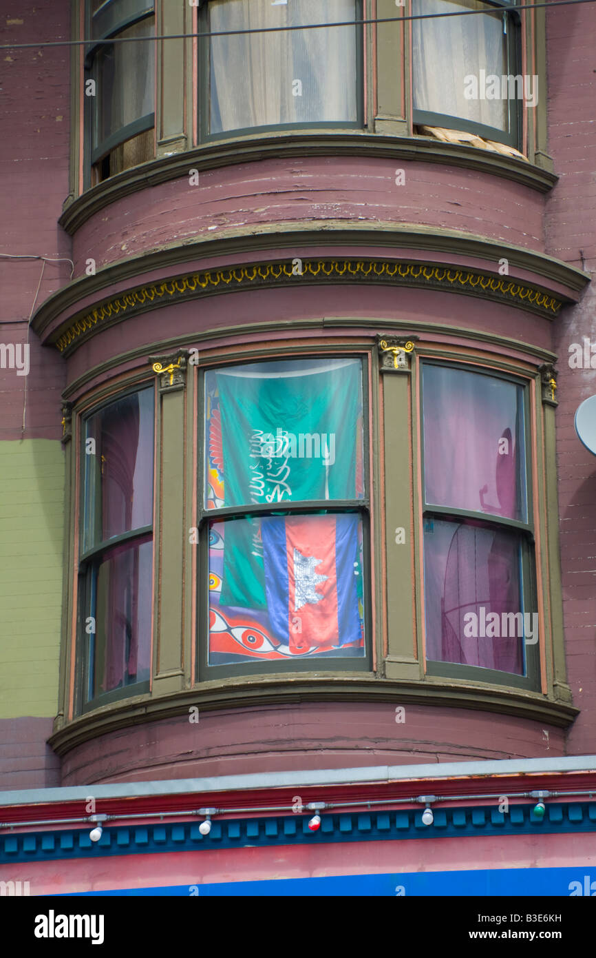 Die Flaggen Saudi-Arabiens und Kambodscha dienen als Vorhänge in einem Zeitfenster von einem viktorianischen Haus in San Francisco. Stockfoto