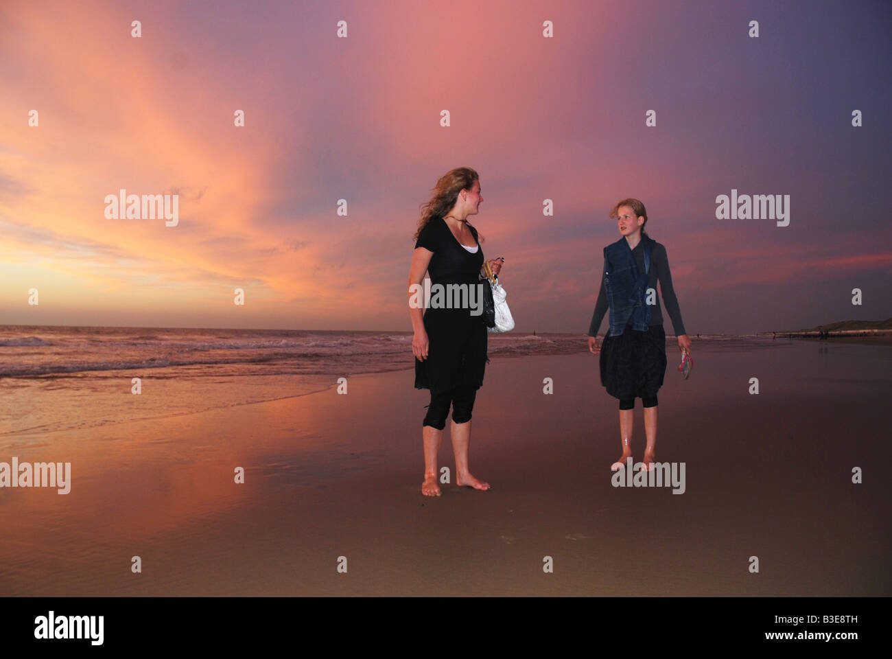 Strand Szene Mit 2 Madchen Bei Sonnenuntergang Stockfotografie Alamy