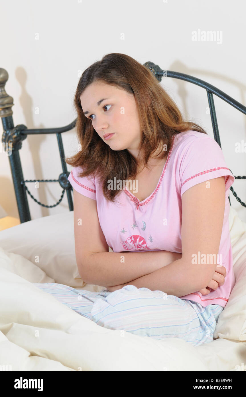 ein Mädchen im Bett mit Magenschmerzen krank fühlen Stockfoto