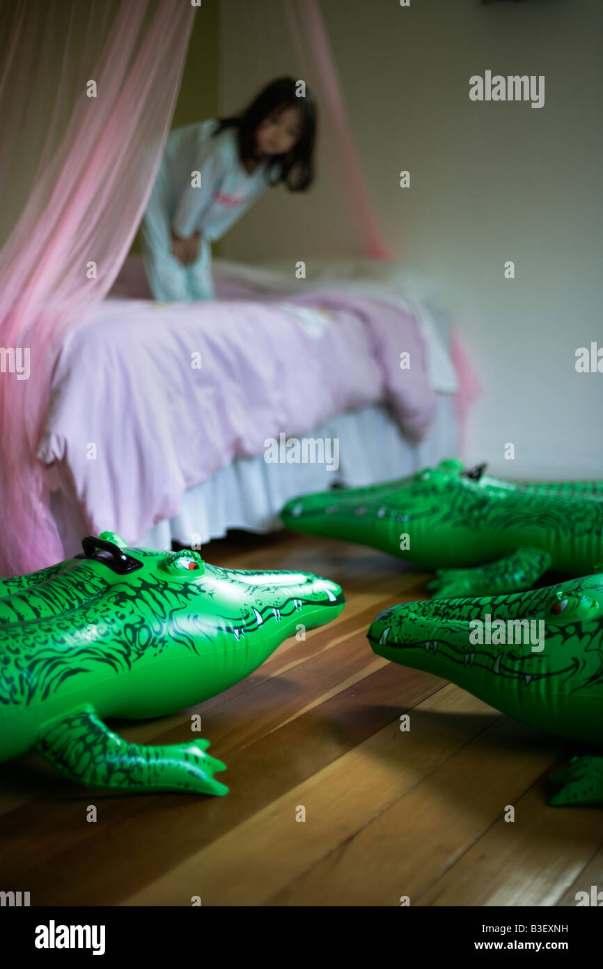 Aufblasbare Krokodil Serie durch ein Kinderbett s lauern Stockfoto
