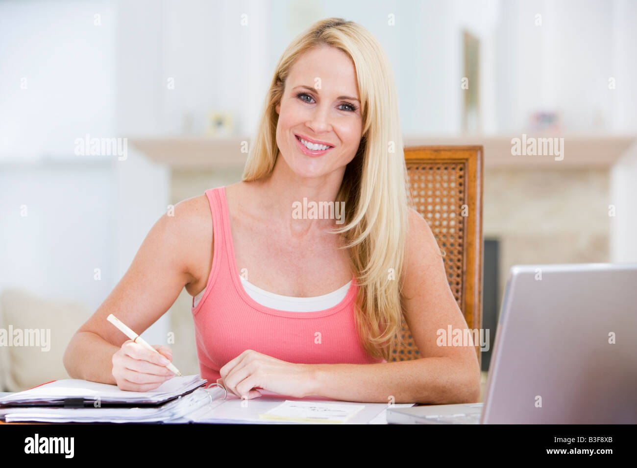 Frau in der Küche mit Zeitung und Kaffee lächelnd Stockfoto