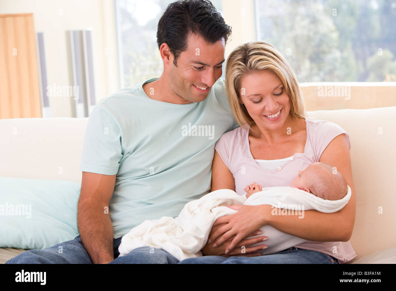 Paar im Wohnzimmer mit Baby Lächeln Stockfoto