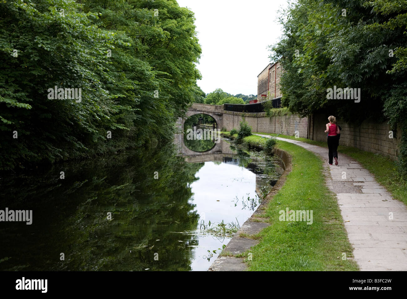 Läufer auf dem Kanal Treidelpfad Leeds und Liverpool Canal Leeds Bereich West Yorkshire UK Aug 2008 Stockfoto