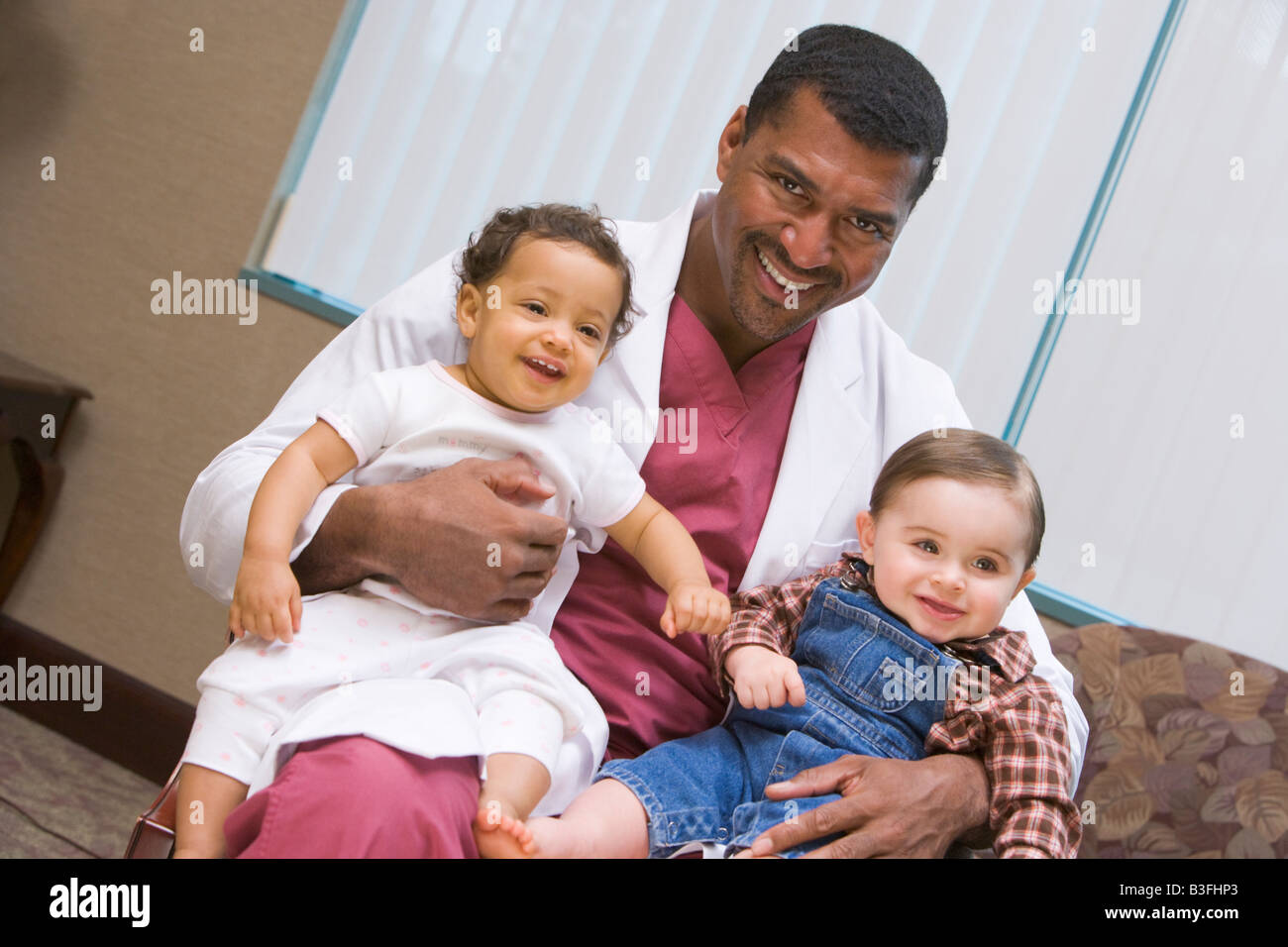 Arzt mit zwei IVF-Kinder Lächeln sitzen Stockfoto