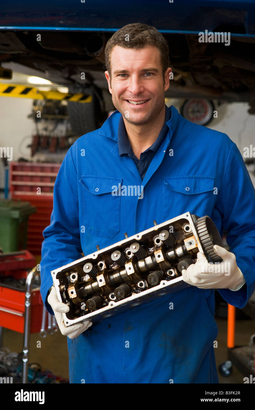 Mechaniker Auto Teil lächelnd halten Stockfoto