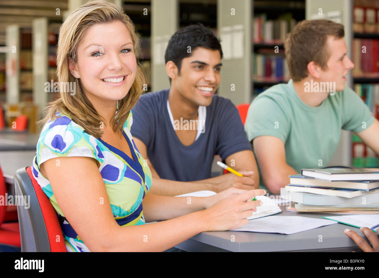 Drei Menschen in Bibliothek studieren (Tiefenschärfe) Stockfoto