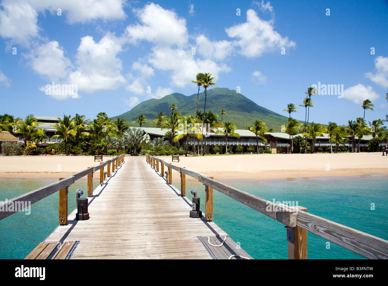 Pinneys Strand mit Kokospalmen und der Vulkan in der Ferne auf Nevis Karibik Stockfoto