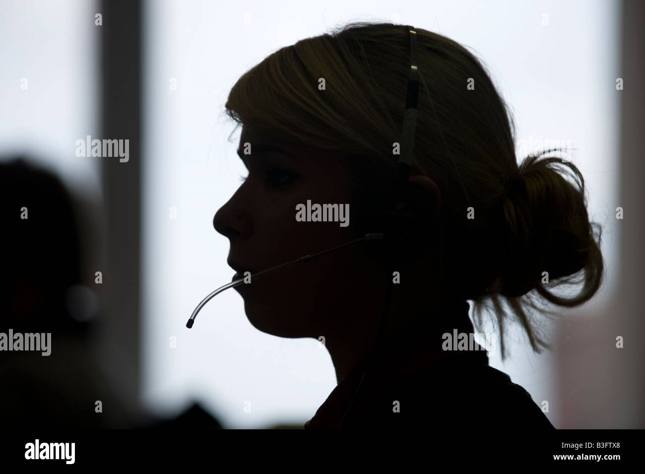 Eine Frau erhält Telefonanrufe in einem UK-Call-Center Stockfoto