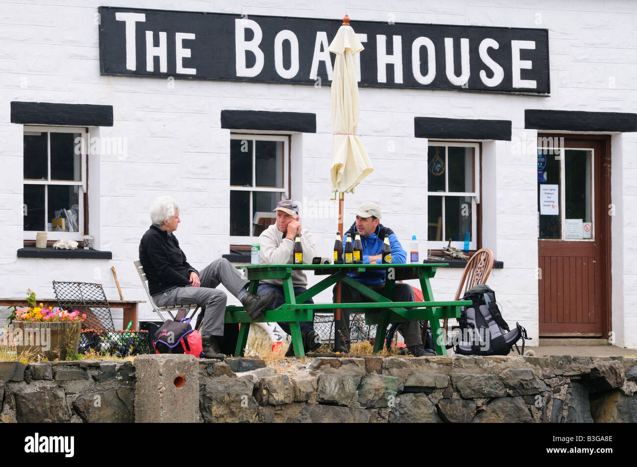 Erwachsene Wanderer einen Drink vor dem Bootshaus, zeigen die Fähre für die Insel ulva Stockfoto