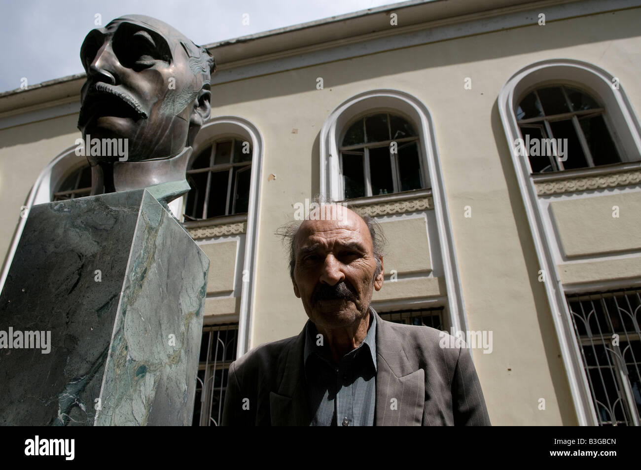 Ein georgischer Mann steht neben der Büste des berühmten georgischen Psychiaters Avlip Surabaschwili in der Stadt Gori in Georgien Stockfoto