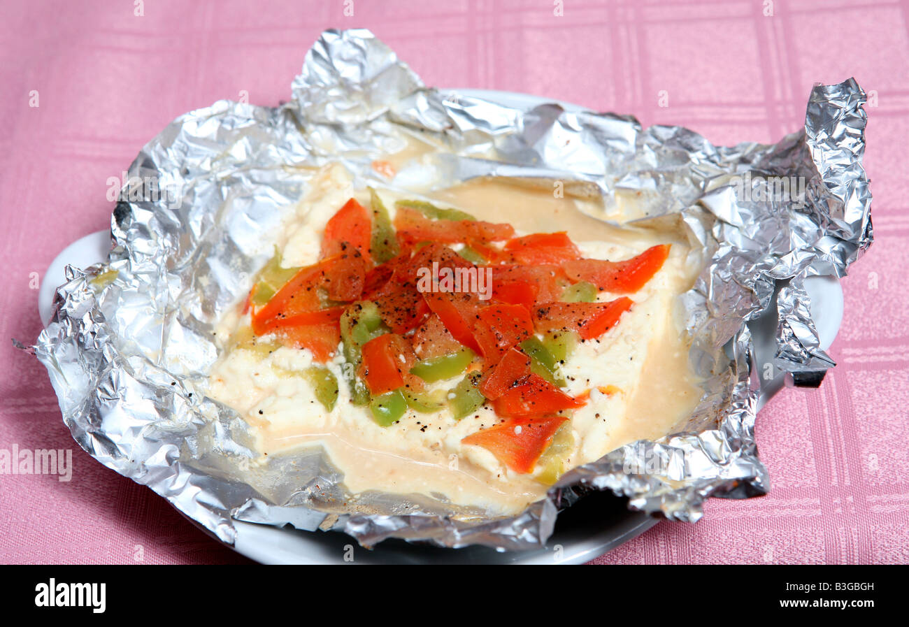Feta-Käse gebacken in Alufolie mit gewürfelten Tomaten und Paprika,  garniert mit einer Prise oregano Stockfotografie - Alamy