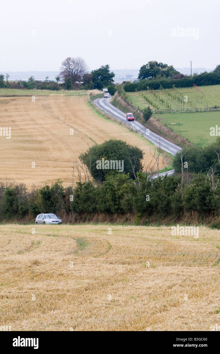 Kurvenreiche Straße überquert abgeernteten Weizenfelder auf Hoo Halbinsel North Kent UK Stockfoto